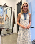 Woman wearing alemais patterned dress standing in front of a mirror.