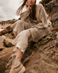 Estilo Emporio Linen Pant Novo Flare - Brasile Natural worn by model in natural setting LUXAMORE