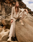 Estilo Emporio Linen Pant Novo Flare - Brasile Natural worn by model in natural setting LUXAMORE