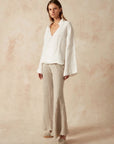 Estilo Emporio Linen Pant Novo Flare - Brasile Natural worn by model in natural setting LUXAMORE