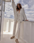 Estilo Emporio Linen Pant Novo Flare - Brasile Panna White worn by model in natural setting LUXAMORE