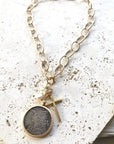 Pre Order Chunky coin necklace cross matte gold jewelry worn by model in natural setting LUXAMORE