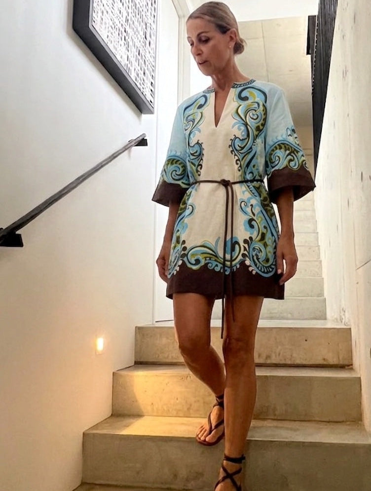Woman in a patterned dress standing on a staircase