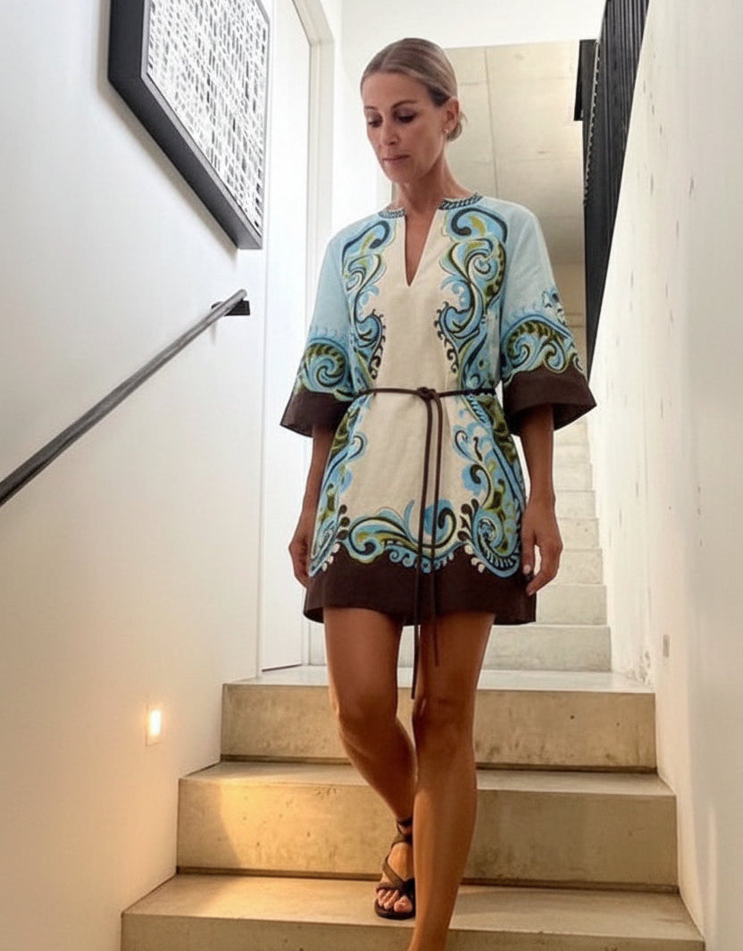 Woman in a patterned dress standing on a staircase