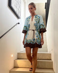 Woman in a patterned dress standing on a staircase