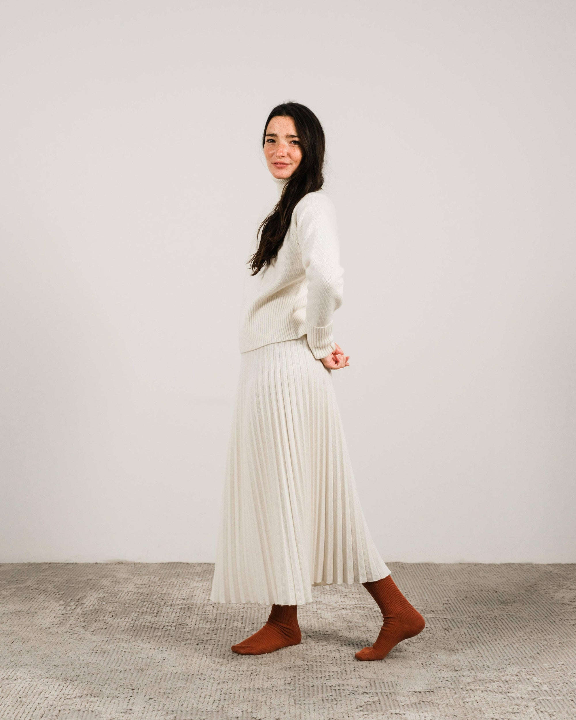 Cashmere pleated skirt Made in Italy by Lemme - Caramello worn by model in natural setting LUXAMORE 