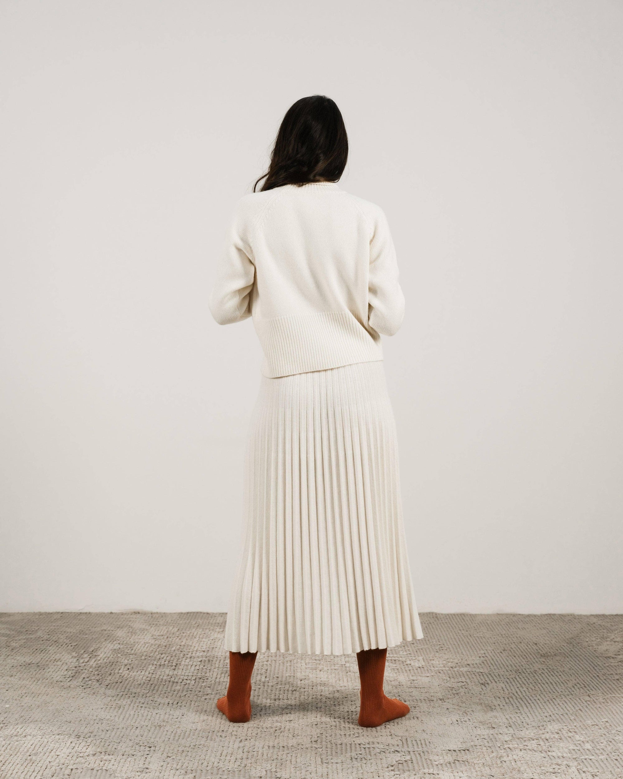 Cashmere pleated skirt Made in Italy by Lemme - Caramello worn by model in natural setting LUXAMORE 
