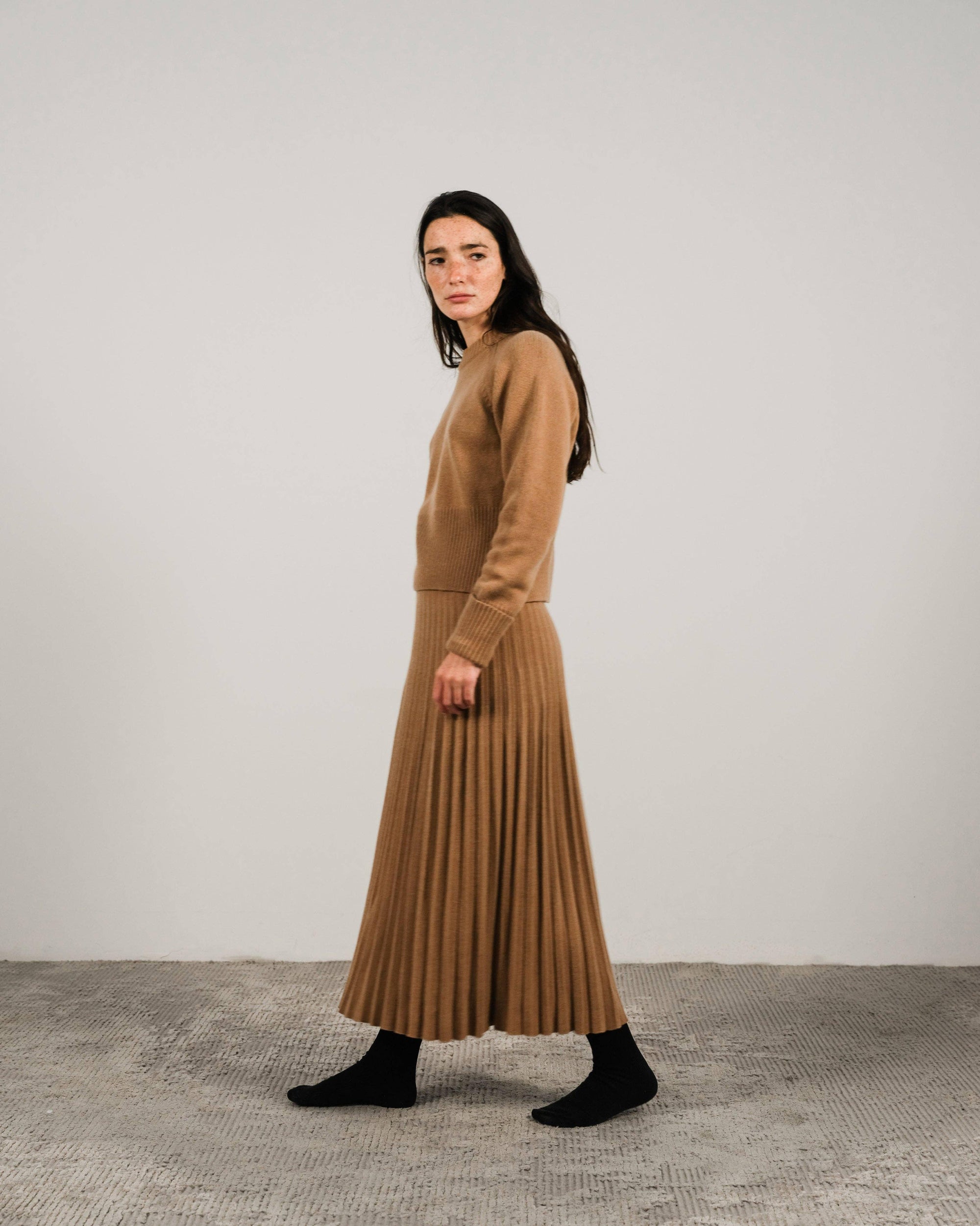 Cashmere pleated skirt Made in Italy by Lemme - Caramello worn by model in natural setting LUXAMORE 