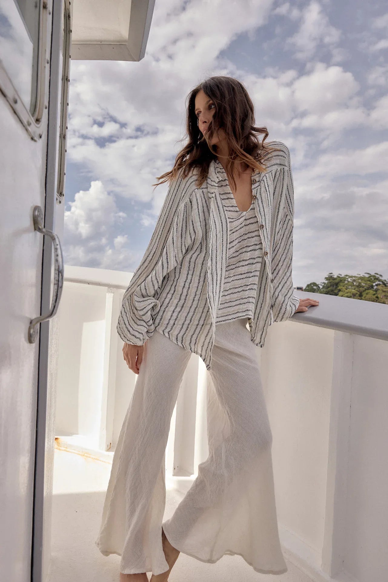Estilo Emporio Linen Pant Novo Flare - Brasile Panna White worn by model in natural setting LUXAMORE 