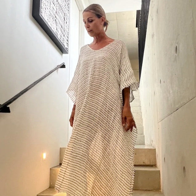 Estilo Emporio dress the Pirata Kaftan worn by model walking down stairs at home.